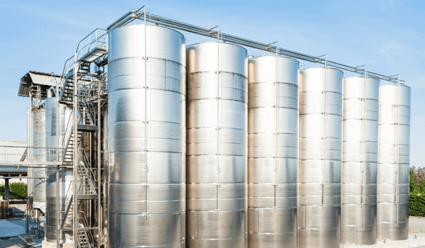 Bateria de tanques verticais de aço inox em planta industrial